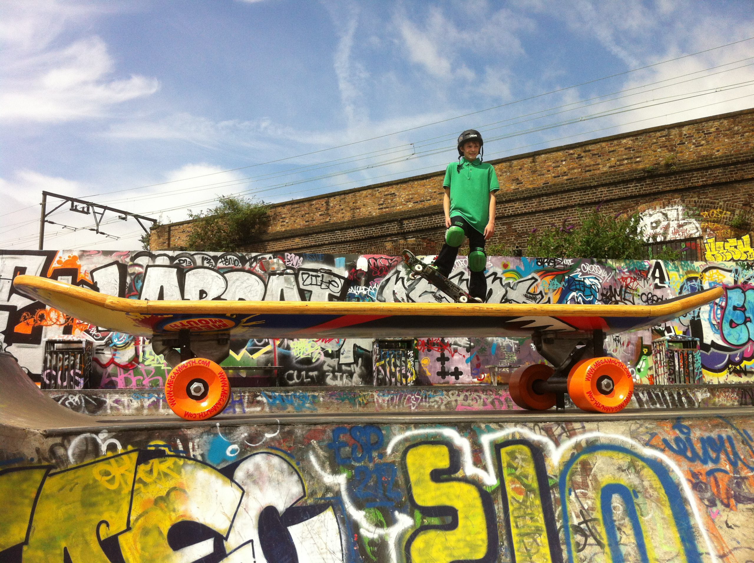 A model of a large skateboard with a person with a small skateboard on top