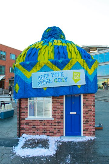 A small house that has a blue and yellow hat on top