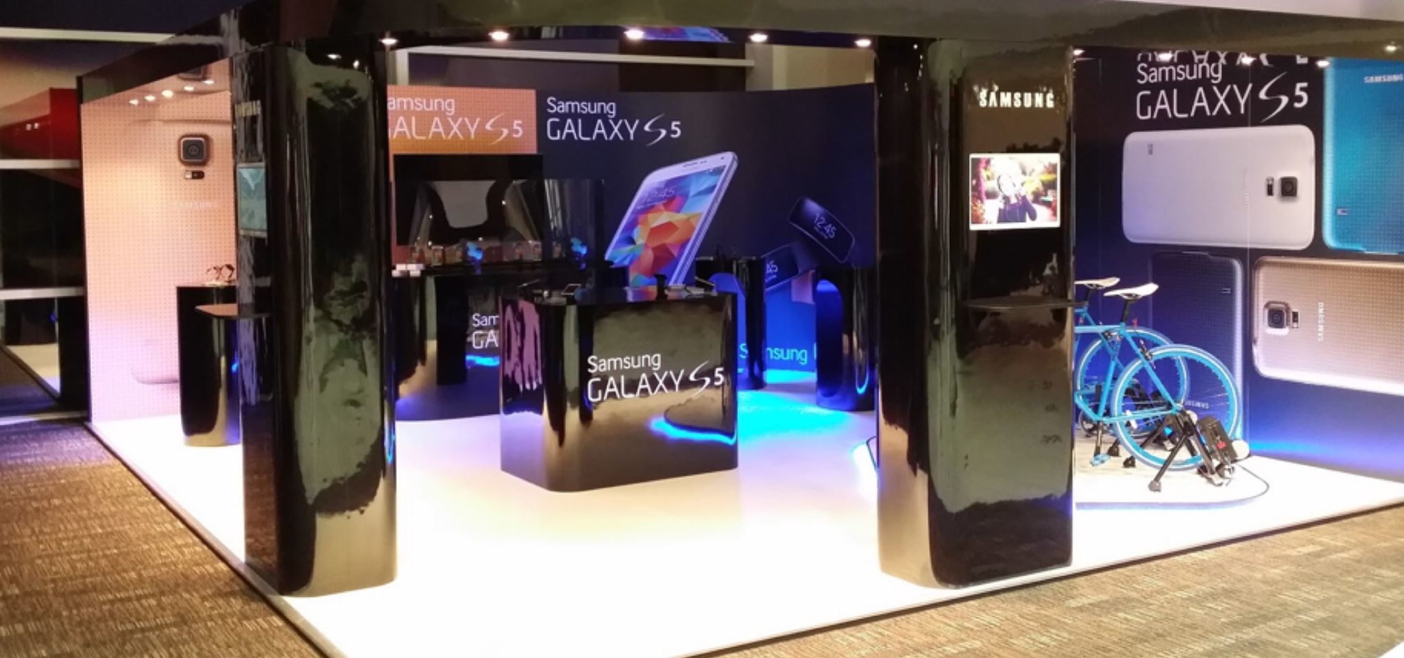 A setup of phones and bikes with blue lighting promoting Samsung