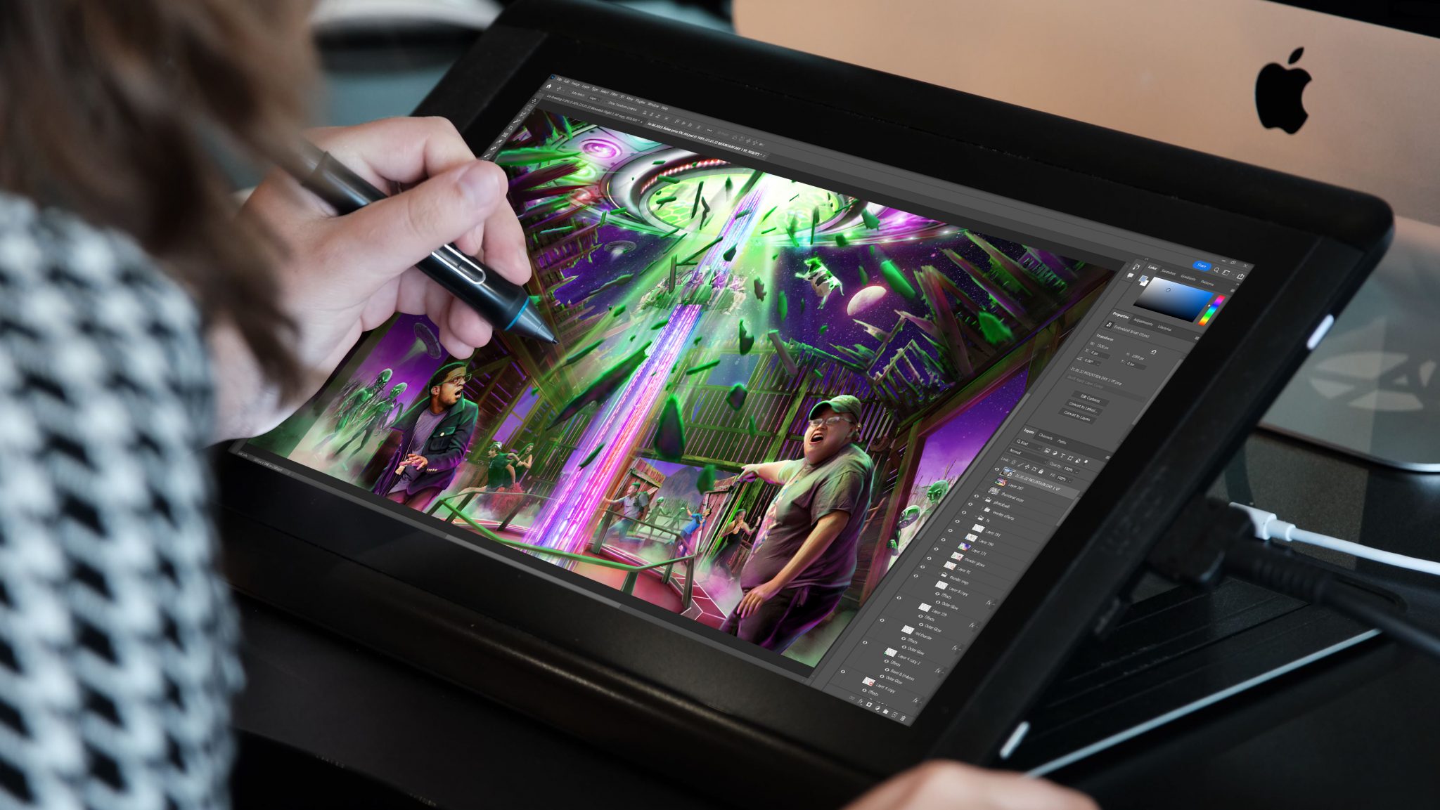A persons hand drawing on a tablet an image of people in a green and purple world