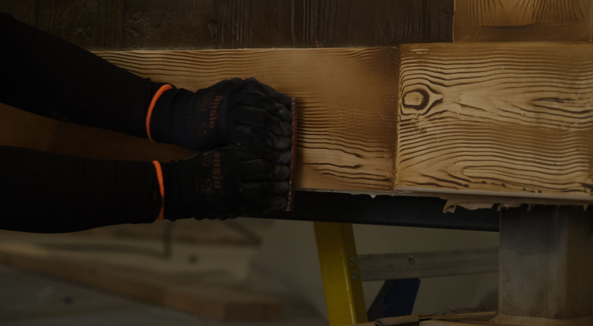 A close-up of a person decorating wood, with traditional wood like markings