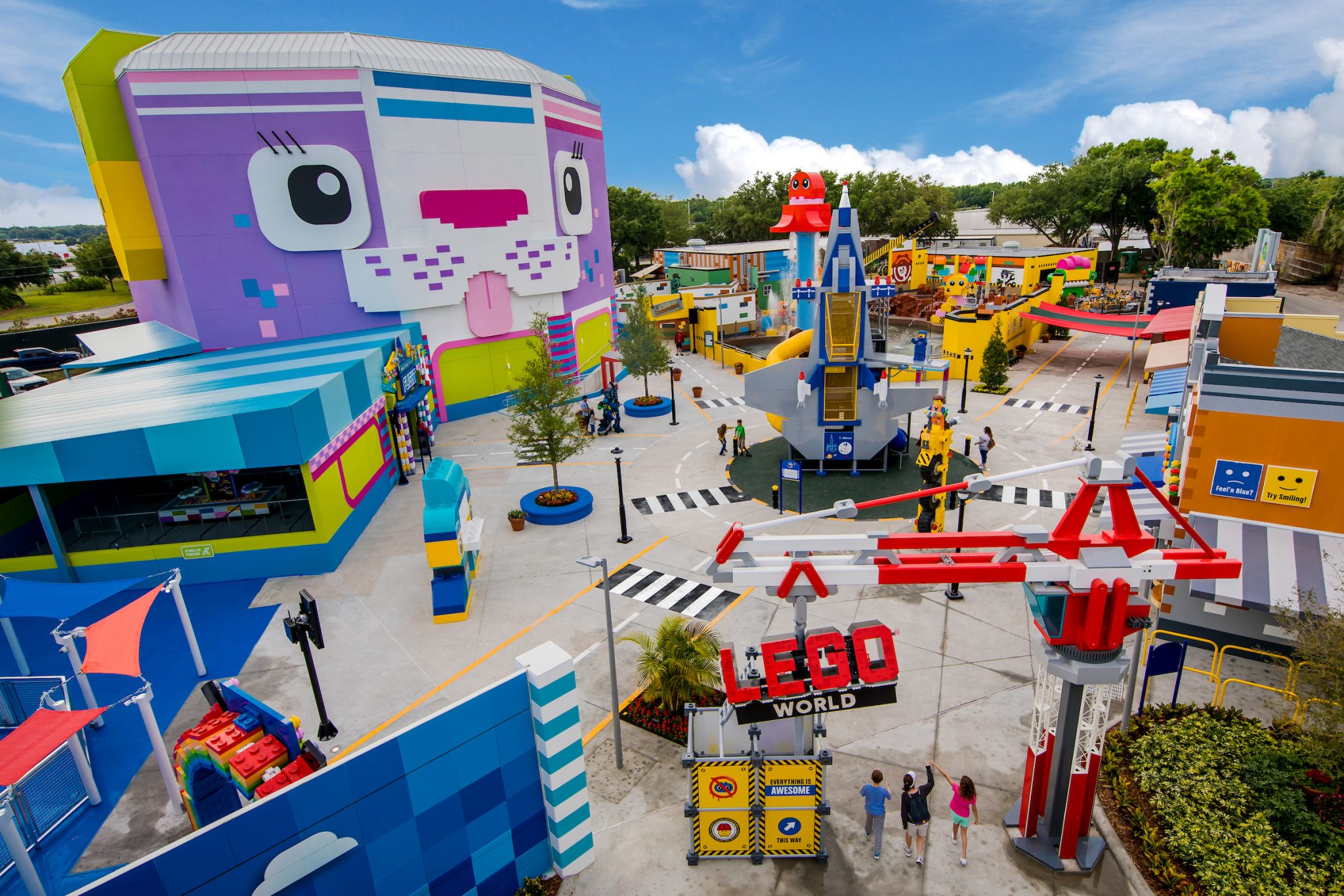 An above shot of LEGO world with a large building of a purple cat made out of LEGO