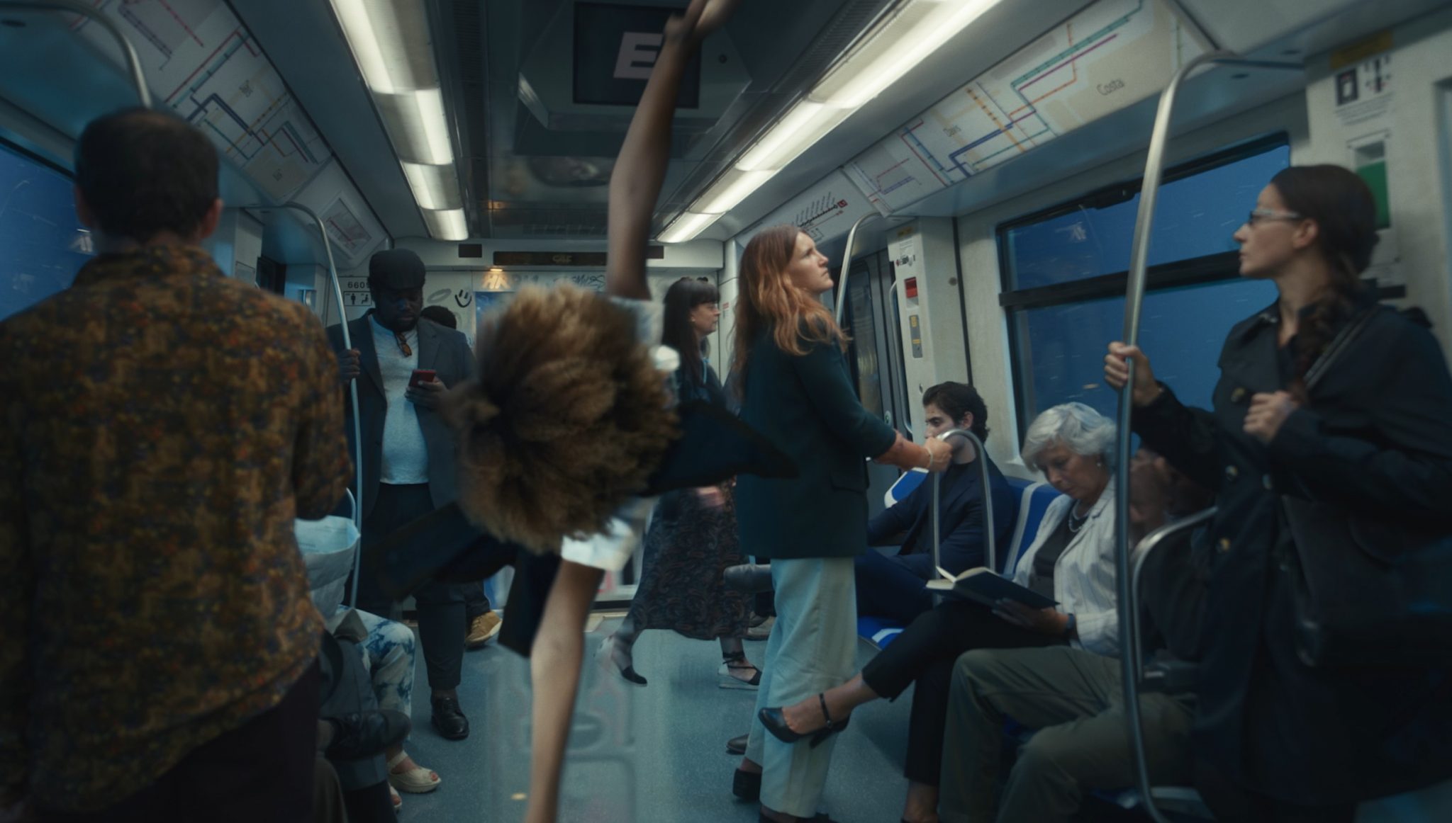 People on a train carriage with a person in the middle in the air